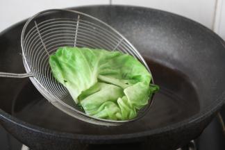 将一片片的包菜焯水，焯水后过凉水，沥干水分备用。