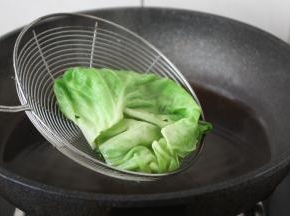 将一片片的包菜焯水，焯水后过凉水，沥干水分备用。