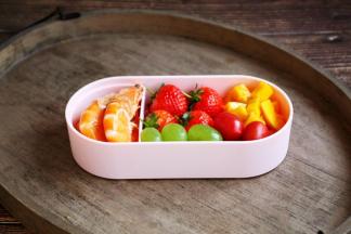 将鲜虾放在便当盒的小隔断盒里，依次放入草莓、葡萄、芒果、小番茄。