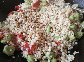 撒入1勺生抽，让米粒上色，再把清洗的薏米倒入一起翻炒，增加不同口感。