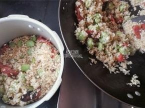 米粒炒制干香，把炒锅中的食材转移到高压锅中煮制。