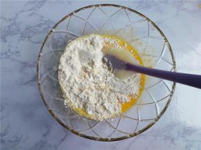 接着筛入低筋面粉，用刮刀翻拌均匀，面糊无干粉，无颗粒即可。