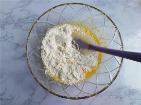 接着筛入低筋面粉，用刮刀翻拌均匀，面糊无干粉，无颗粒即可。