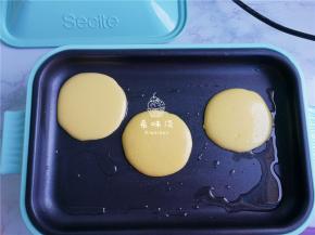 把面糊装入裱花带中，锅热后，就把面糊挤入盘中，一个小圆饼形状。