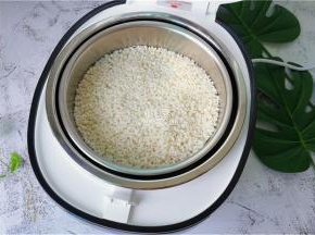 把浸泡好的糯米倒入甑子中，倒入适量的清水蒸制。