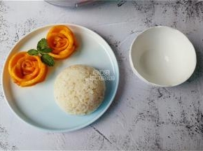 用芒果摆点造型，米饭盛入碗中倒扣在碗中，浇入少许椰浆搭配即可。