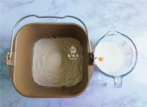 首先来制作面团：把面粉，奶粉倒入面包桶中，接着倒入白砂糖，酵母，盐（盐和酵母要对角）再倒入液体：鸡蛋，牛奶，食用油，启动面包机揉。