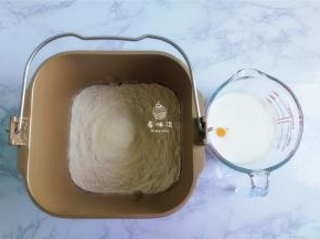 首先来制作面团：把面粉，奶粉倒入面包桶中，接着倒入白砂糖，酵母，盐（盐和酵母要对角）再倒入液体：鸡蛋，牛奶，食用油，启动面包机揉。