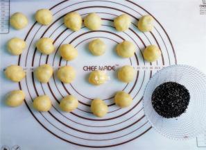 把小面团依次沾点熟芝麻，放入锅中进行烤制。