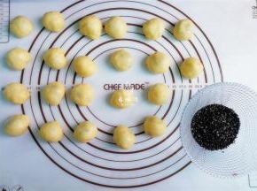 把小面团依次沾点熟芝麻，放入锅中进行烤制。