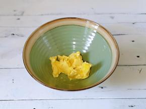 将软化的黄油放入大口器具中。