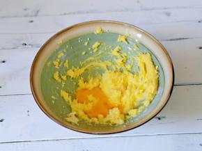 分两次加入全蛋液，继续启动电动打蛋器，打至蛋液与黄油完全融合。