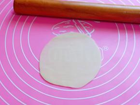 取一张饺子皮，用擀面擀薄。