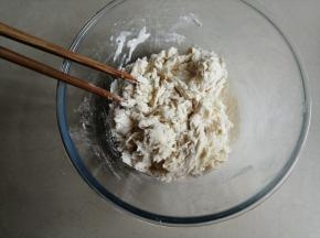 把酵母水倒入面粉里，用筷子拌成絮状