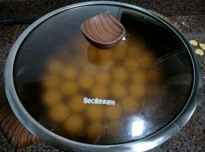烙一分钟，翻一下面。 然后盖上盖子，让小饼更易熟透。 烙至两面微微金黄。