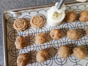 用五十克的月饼模具按压出花型，一般按到第八个就开始粘模具了，换一个花片继续按压