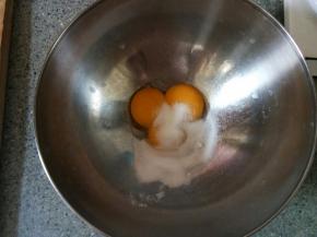 蛋黄里分次加入细砂糖搅拌至糖融化