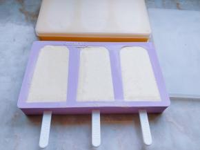 将雪糕棒从模具内朝外插好，把雪糕糊倒入其中，轻震几下模具，颠出气泡。用刮刀抹平表面。