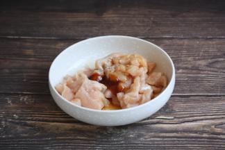 鸡肉片里放入1g的白胡椒粉、1勺的料酒、1g的盐、1小勺的生抽、1勺的蚝油、1勺的淀粉。