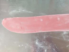 红色面团擀成长长的薄片