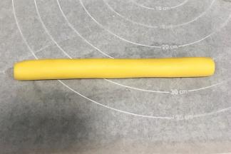 把原色面团揉成长圆柱状，长约18厘米。