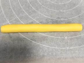 把原色面团揉成长圆柱状，长约18厘米。