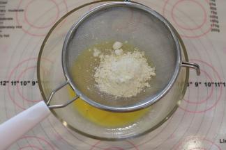 手动打蛋器搅拌至蛋黄和酸奶混合均匀，筛入低筋面粉。