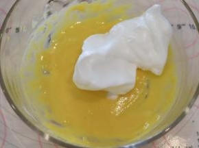 取1/2的蛋白加入到蛋黄糊内，翻拌手法混合好蛋糕糊。