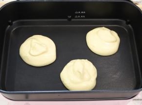 用大汤勺勺起一勺蛋糕糊，放入预热好的锅内。