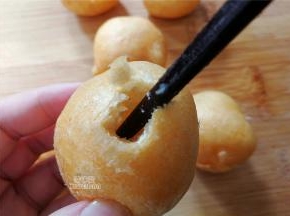 拿一根筷子把油面筋戳个洞，搅碎内部组织，动作轻软点，别把油面筋戳碎，洞口不要太大。