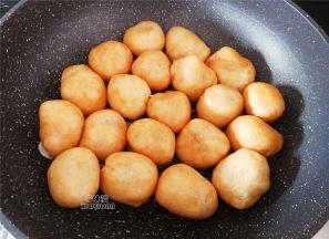 热锅起油，放入切片的蒜瓣爆香，再把塞好肉的油面筋洞口朝下，一个一个倒入锅中煎制下。