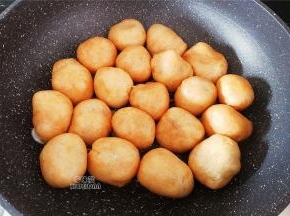 热锅起油，放入切片的蒜瓣爆香，再把塞好肉的油面筋洞口朝下，一个一个倒入锅中煎制下。