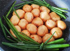 洞口的已经肉熟了封口后，倒入适量清水，放入点老抽，开大火炖煮，小葱打结后放入一起炖煮，汤汁沸腾了，油面筋变软了，就稍微收下汁就可以装盘食用了。