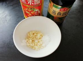 在腌制的过程中调制料汁，蒜瓣切蓉和白砂糖一起放入碗中，接着倒入2勺蒸鱼豉油和半勺黑米醋，均匀的搅拌融化备用。