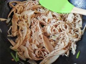 把煮好的笋干倒入锅中翻炒下，均匀混合葱油的味道，再把放入和生抽继续翻炒。