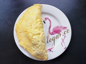 把炒饭倒入蛋皮一边，再对折回来盖起来。犹如一个大饺子，挤入点甜辣酱即可开食。