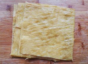 准备豆腐皮，剪出大小相同的正方形，泡入水中，泡软为止。