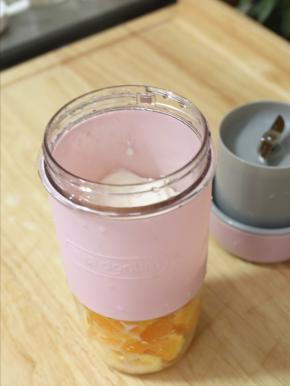 香橙去皮切块，记得白色部分要去除干净一些。把它们扔进东菱无线果汁机中，加入牛奶和糖。