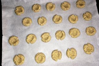 把饼干放在烤盘中，每个之间留出一定的距离。饼干中间用手指按个洞，如图。