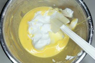 取三分之一蛋白加入蛋黄糊中，用刮刀翻拌均匀。不要画圈搅拌。