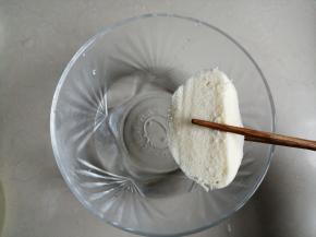 夹起馒头片，在盐水中沾一下，就随便沾一下即可