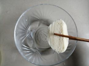 夹起馒头片，在盐水中沾一下，就随便沾一下即可