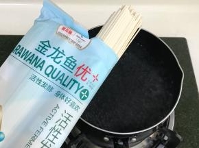 锅内倒入适量的清水烧开，把金龙鱼活性空心挂面放入锅中。