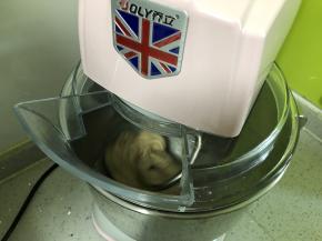 然后加入软化的黄油，先用2档中速揉面将黄油与面团搅拌均匀，再用5档高速揉面15分钟，揉至面团表面变得光滑。