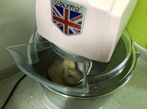 然后加入软化的黄油，先用2档中速揉面将黄油与面团搅拌均匀，再用5档高速揉面15分钟，揉至面团表面变得光滑。