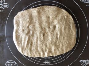 把面团放在揉面垫上按压排气。