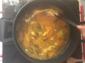 平底不粘锅烧热后倒入鸡蛋液，小火划圈不断搅动。