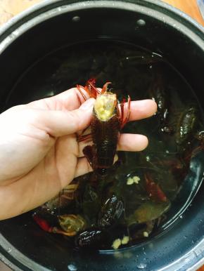 用剪刀在小龙虾的眼睛后处剪去沙囊，留下虾黄可以放心享用