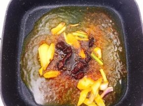 然后下入干锅调料，花椒油炒香