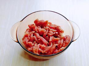 切好的肉丝放入器具中，加入料酒，盐，油，糖，淀粉抓拌均匀。